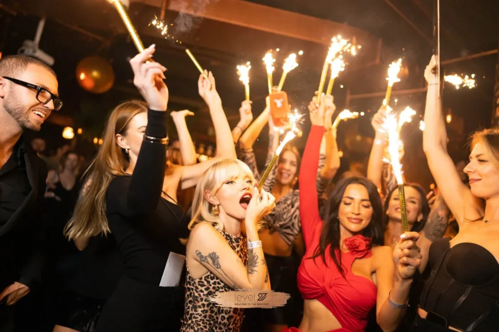 Guests enjoying a vibrant party at a Warsaw nightclub with sparklers, highlighting the exclusive Warsaw nightclub door policy.
