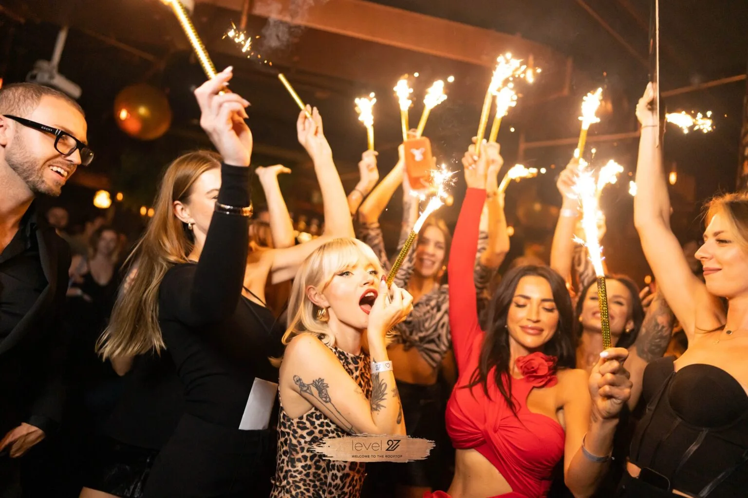 Guests enjoying a vibrant party at a Warsaw nightclub with sparklers, highlighting the exclusive Warsaw nightclub door policy.